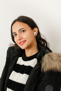 Portrait of young woman against white background