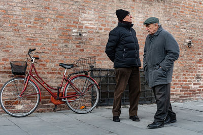 Man with bicycle standing on wall