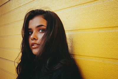 Close-up of woman standing by wall