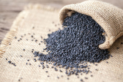 Close-up of black sesame seeds in sack on table