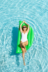 Full length of smiling young man in swimming pool