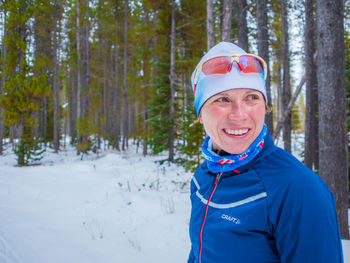 Portrait of smiling woman standing in forest