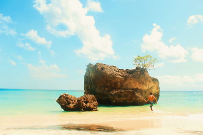 Scenic view of rocks on beach against sky