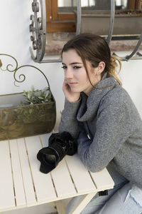 Teenage girl with camera on table