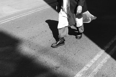 Low section of man walking on street