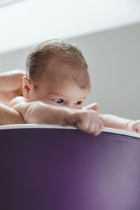 Cropped hands of mother bathing baby girl in bathtub