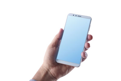 Close-up of hand holding mobile phone over white background