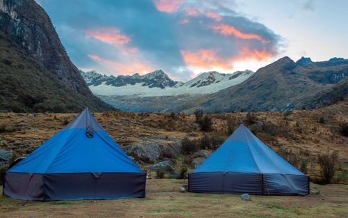 Scenic view of tent on mountain against cloudy sky