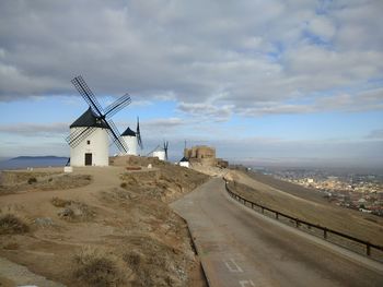 Traditional windmill on landscape against sky