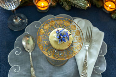 Cheesecake dessert and whipped cream with gold dust on a fancy crystal glass dish with gold etching.