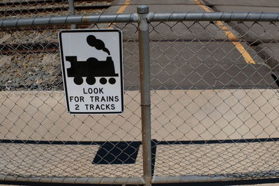 Close-up of warning sign on chainlink fence