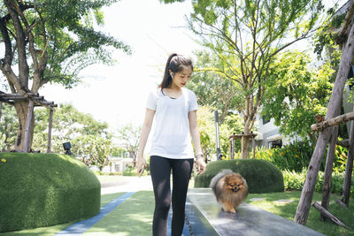 Young woman with dog walking at park