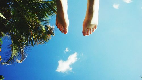 Low section of woman against blue sky