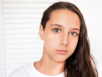 Portrait beautiful young caucasian tanned girl white background closeup brown long health hair. calm