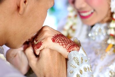 Groom kissing hands of bride