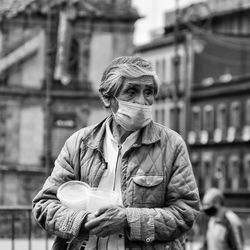 Portrait of man holding camera in city