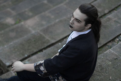 High angle view of thoughtful young man sitting on steps 