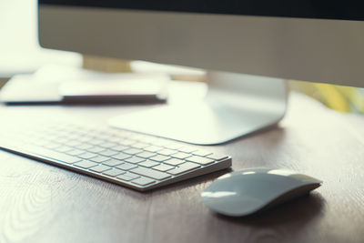 High angle view of keyboard and mouse by desktop pc on desk