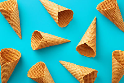 Full frame shot of empty waffle ice cream cones against blue background
