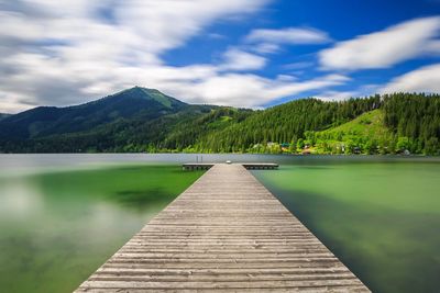 Pier over lake against mountains