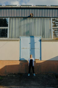 Full length of woman standing against building