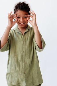 Portrait of young woman gesturing against white background