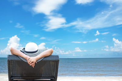 Man wearing hat at beach against sky