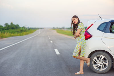 Full length of woman standing on road