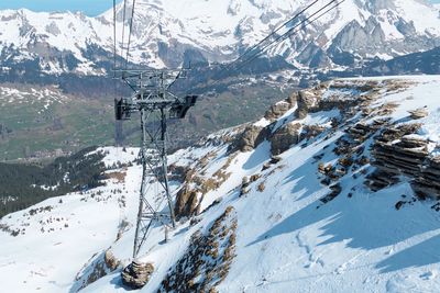 Overhead cable cars over snowcapped mountains