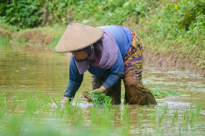 Full length of woman working in water.