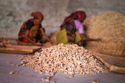 Close-up of ginger with women working in background