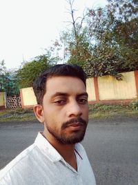 Portrait of young man against road