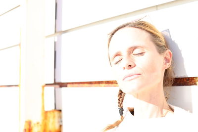 Portrait of young woman with eyes closed window