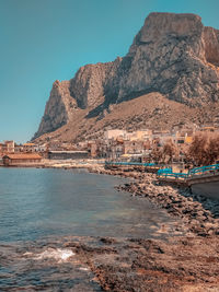 Scenic view of sea and mountains against clear sky