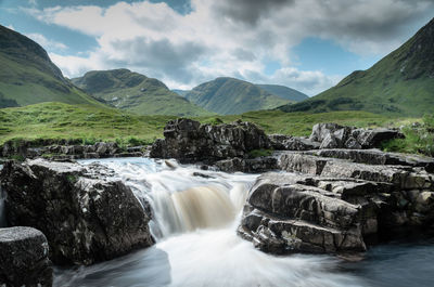 Scenic view of waterfall against sky