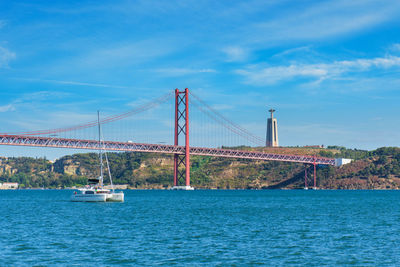 Suspension bridge over sea against sky