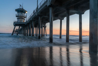 Pier over sea against sky during sunset