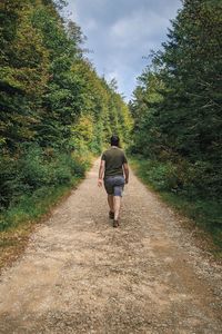 Rear view of woman walking on footpath