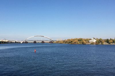 View of bridge over water against clear blue sky