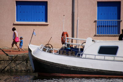 People on boat moored at shore