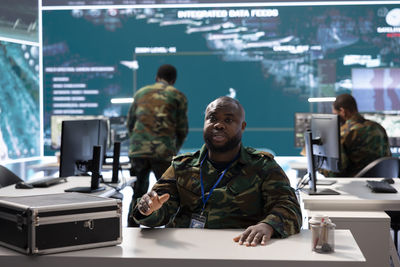 Rear view of people working in office