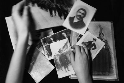 Cropped hands of woman holding photographs