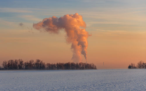 Scenic view of snow covered landscape against sky during sunset