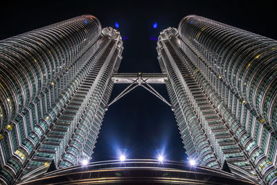 Low angle view of illuminated petronas towers against sky at night