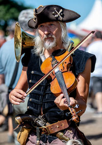 Midsection of man playing violin