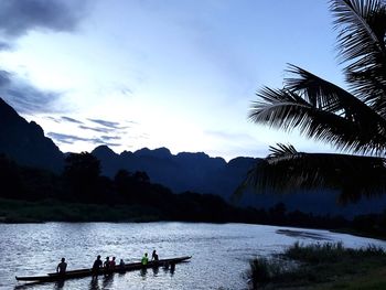 People in boat on lake against sky