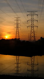 Silhouette electricity pylon against romantic sky at sunset