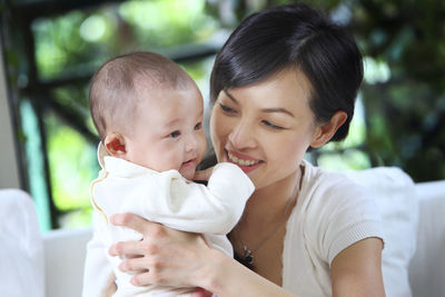 Close-up of mother carrying daughter at home