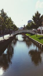 Bridge over river in city against sky