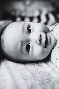 Close-up portrait of baby lying on bed